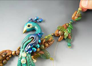 Clay peacock and branches strung together